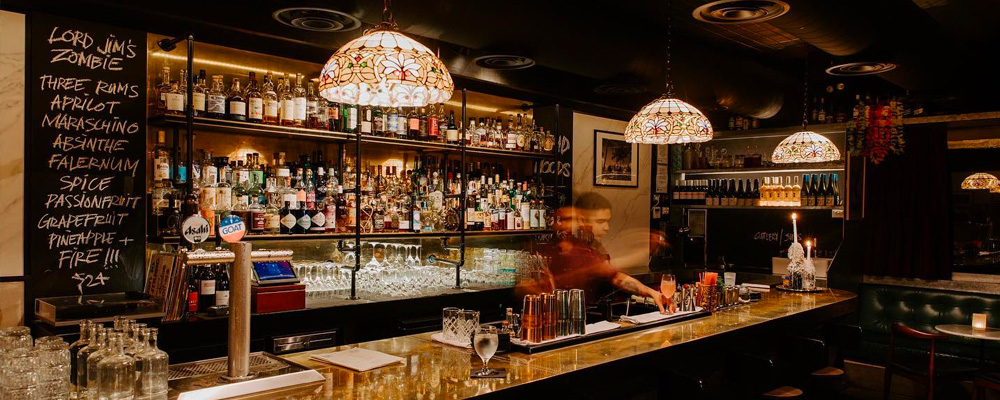 A bartender mixes a drink at High Jinks, a prohibition-style speakeasy just off campus in New Acton.