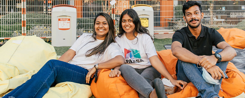 Nakul and two women sit on beanbags on the Kambri lawns.