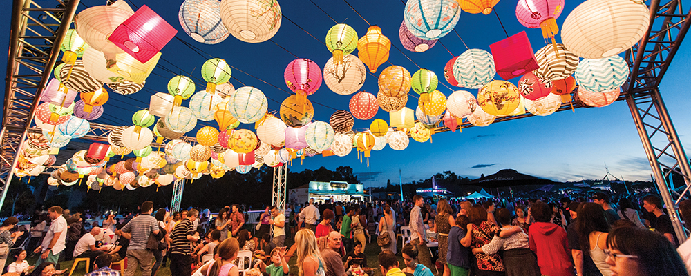 Moon festival lanterns hang overhead while diners enjoy their meals.