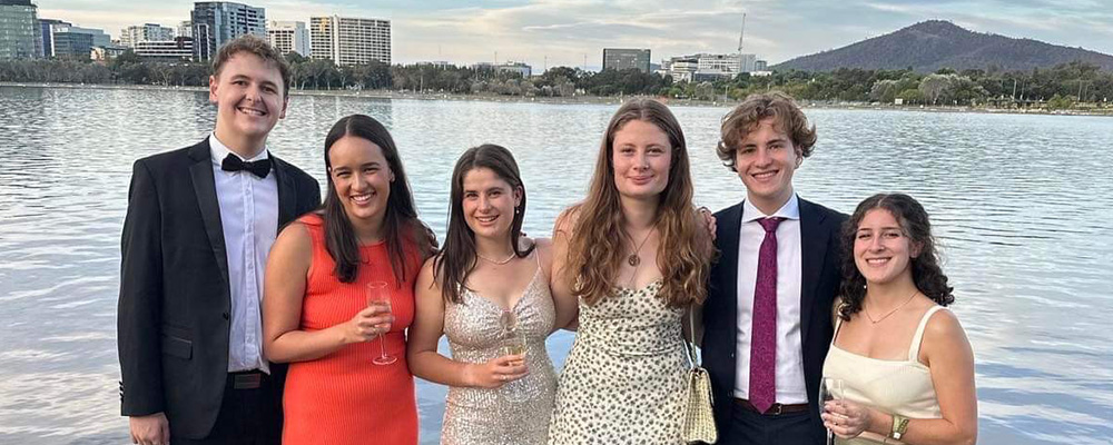 Ulrika Wild celebrating with fellow students on the edge of Lake Burley Griffin.