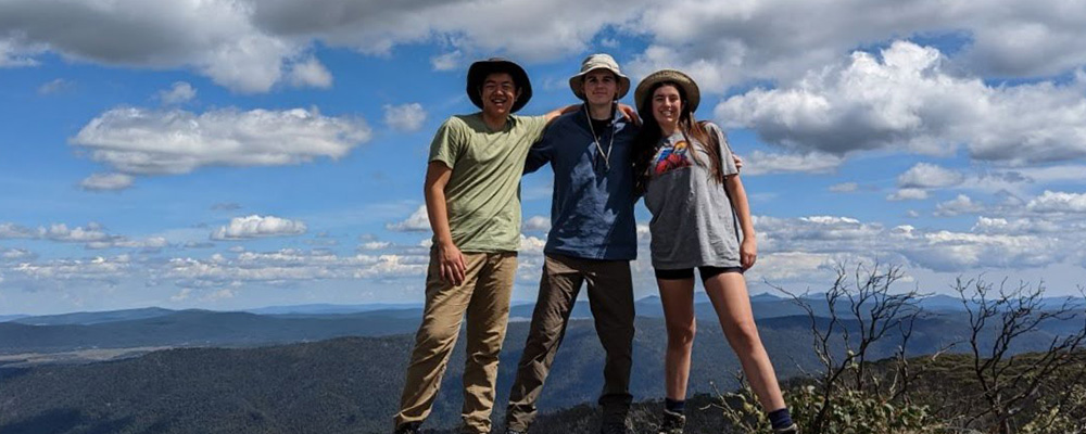 Bo poses with two friends while on a hike.