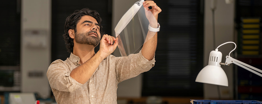 A man examines materials in the ANU Maker Space.