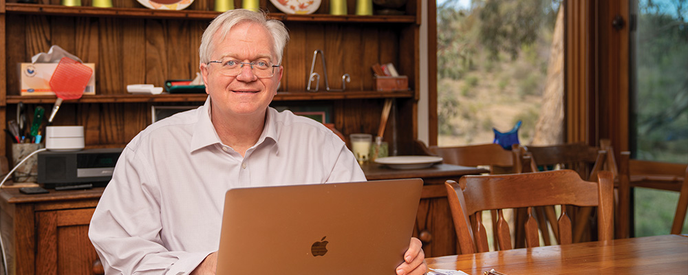 Brian sits in his home office.