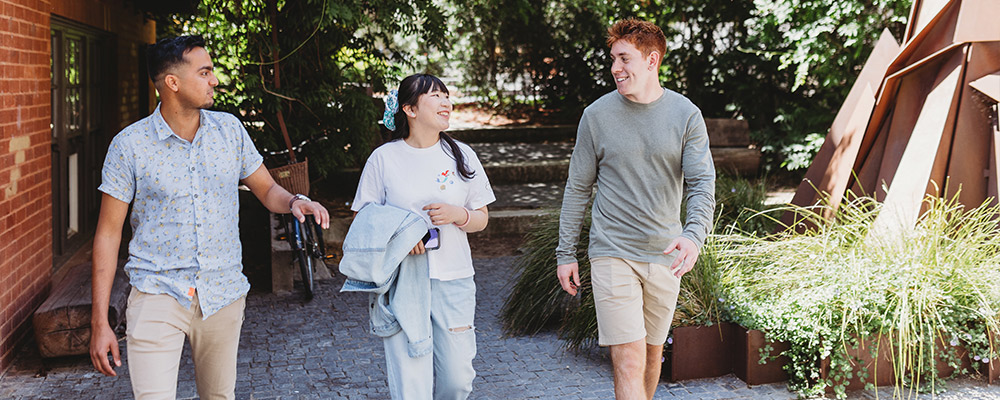 Three roommates walk to class from their share house.