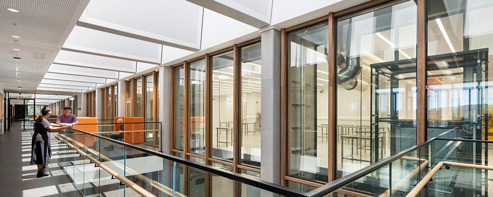 The first room of a building, where people are coming and going. Students sit around a table near the stairs to study.